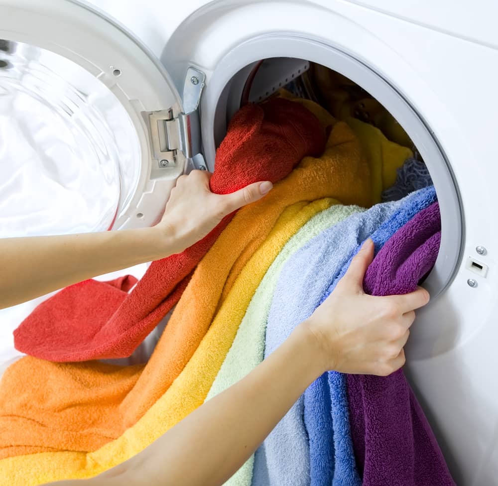洗濯機から七色のタオルを取り出す画像。